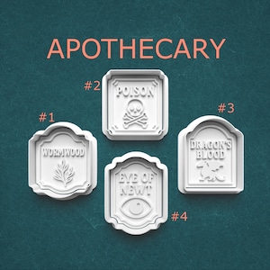 May include: Four white apothecary-themed cookie cutters. The cutters are labeled with the words "Wormwood", "Poison", "Dragon's Blood", and "Eye of Newt". The word "APOTHECARY" is printed in orange at the top of the image.
