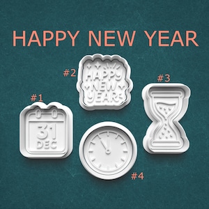 May include: Four white cookie cutters with a New Year's theme. The cutters include a calendar with "31 DEC", a "HAPPY NEW YEAR" design, an hourglass, and a clock. The text "HAPPY NEW YEAR" is above the cutters.