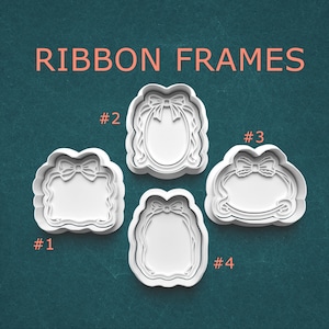 May include: Four white plastic cookie cutters in various shapes, each featuring a ribbon design. The cutters are labeled with numbers and the text "RIBBON FRAMES" is displayed in coral-colored letters at the top. The background is a teal color.