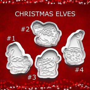 May include: Four white plastic cookie cutters in the shape of Christmas elves, each with a unique design. The cutters are numbered 1 through 4 and are set against a red background with the words "CHRISTMAS ELVES" in white.