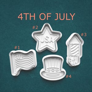 May include: Four white cookie cutters in the shape of a flag, star with "USA" text, a firework, and a top hat. The text "4TH OF JULY" is in orange above the cookie cutters. The cookie cutters are numbered 1 through 4.