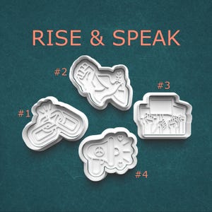 May include: Four white plastic cookie cutters with different designs. The cutters are labeled #1, #2, #3, and #4. The designs include a raised fist with a dove, a megaphone with a peace sign, a chain link, and a group of people holding signs.