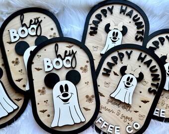 May include: Four wooden signs with a Halloween theme. The signs feature a ghost with Mickey Mouse ears, the text "Happy Haunts", "Hey Boo", and "Served with Scream & Sugar".