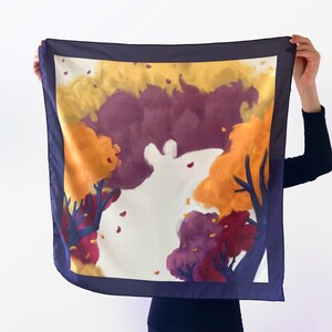 May include: A silk scarf with a navy blue border and a white background featuring a stylized painting of trees with purple, orange, and yellow leaves.