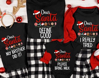 May include: A collection of black Christmas-themed shirts and pajamas with the text "Dear Santa" and various phrases. The shirts have a Santa hat graphic and festive decorations. The pajamas are black and white checkered.