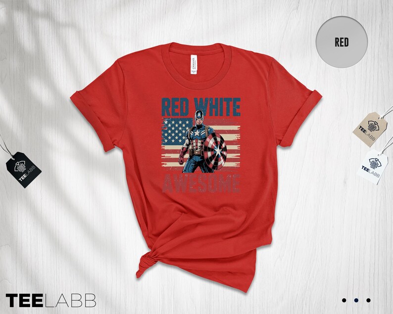 May include: A red short-sleeve t-shirt featuring a graphic of Captain America standing in front of a distressed American flag. The text "RED WHITE" appears in blue above the character, and the word "AWESOME" is printed in blue below.