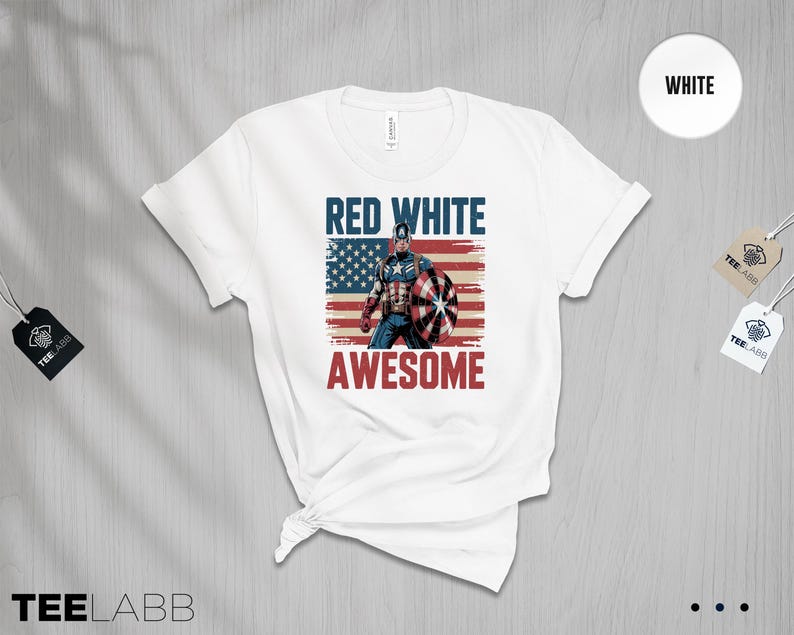May include: A white short-sleeved t-shirt featuring a graphic of a superhero holding a shield in front of a distressed American flag. The text RED WHITE is printed in blue above the figure, and the word AWESOME is printed in red below the figure.