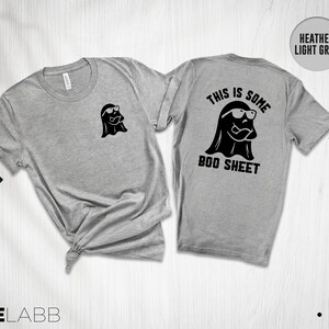 以下が含まれることがあります： ヘザーライトグレーのTシャツに、サングラスをかけた黒い幽霊と「This is some boo sheet」という文字が書かれています。