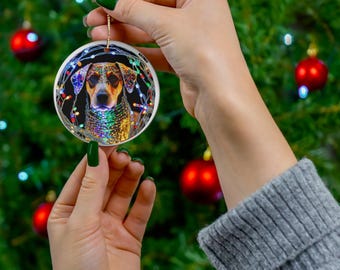 May include: A round white ceramic Christmas bauble featuring a colourful image of a dog surrounded by Christmas lights.