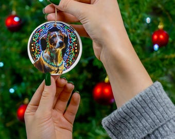 May include: A round ceramic Christmas ornament featuring a dog wearing a colorful beaded necklace. The dog is surrounded by a wreath of colorful lights.