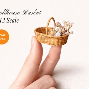 1:12 scale dollhouse miniature oval basket with handle, handmade woven basket sitting on fingers and filled with tiny flowers. Image promoting a DIY dollhouse basket pattern with oval base for miniature basket making.