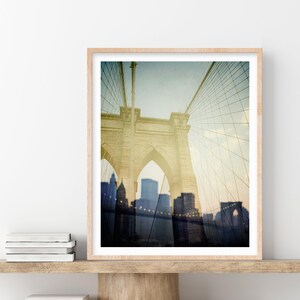 Puede incluir: Una fotograf&iacute;a de estilo vintage del puente de Brooklyn en la ciudad de Nueva York. El puente se muestra en un tono sepia descolorido, con el horizonte de la ciudad visible en el fondo.