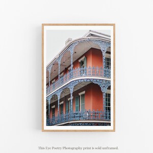 May include: A photograph of a red brick building with blue iron balconies and railings. The building has multiple stories and is decorated with intricate details.