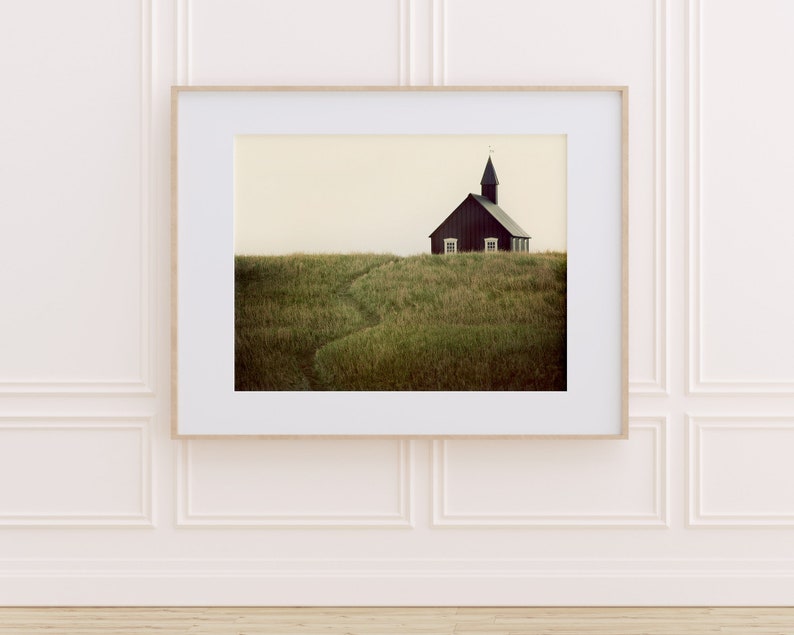 K&ouml;nnte beinhalten: Eine schwarze Holzkirche mit einem Kirchturm steht auf einem grasbewachsenen H&uuml;gel. Die Kirche hat zwei Fenster und eine T&uuml;r. Das Gras ist gr&uuml;n und braun.