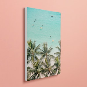 May include: An aerial view of a tropical beach with turquoise water and palm trees. People are swimming and floating in the water.