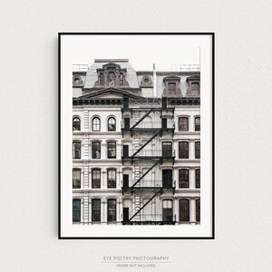 Puede incluir: Una fotograf&iacute;a en blanco y negro de un edificio blanco con una escalera de incendios. El edificio tiene muchas ventanas y un techo marr&oacute;n.