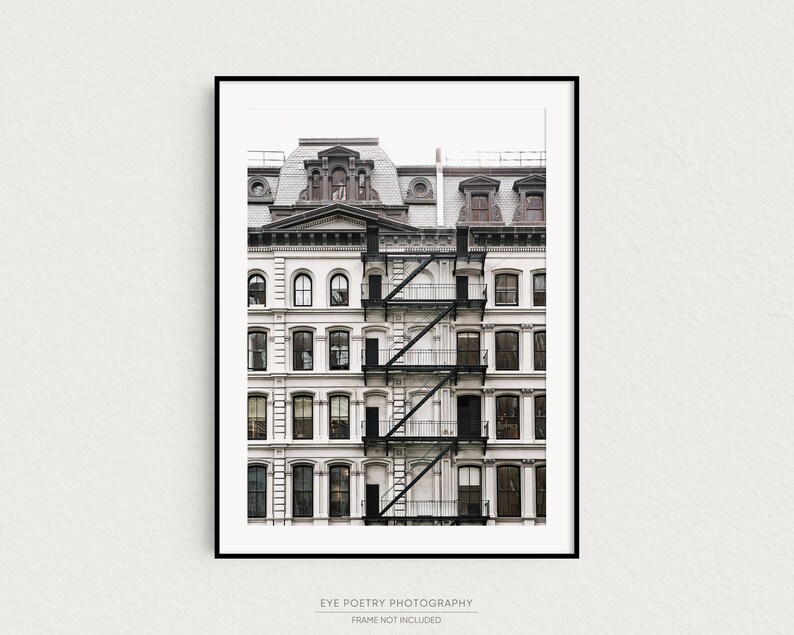 Puede incluir: Una fotograf&iacute;a en blanco y negro de un edificio blanco con una escalera de incendios. El edificio tiene muchas ventanas y un techo marr&oacute;n.