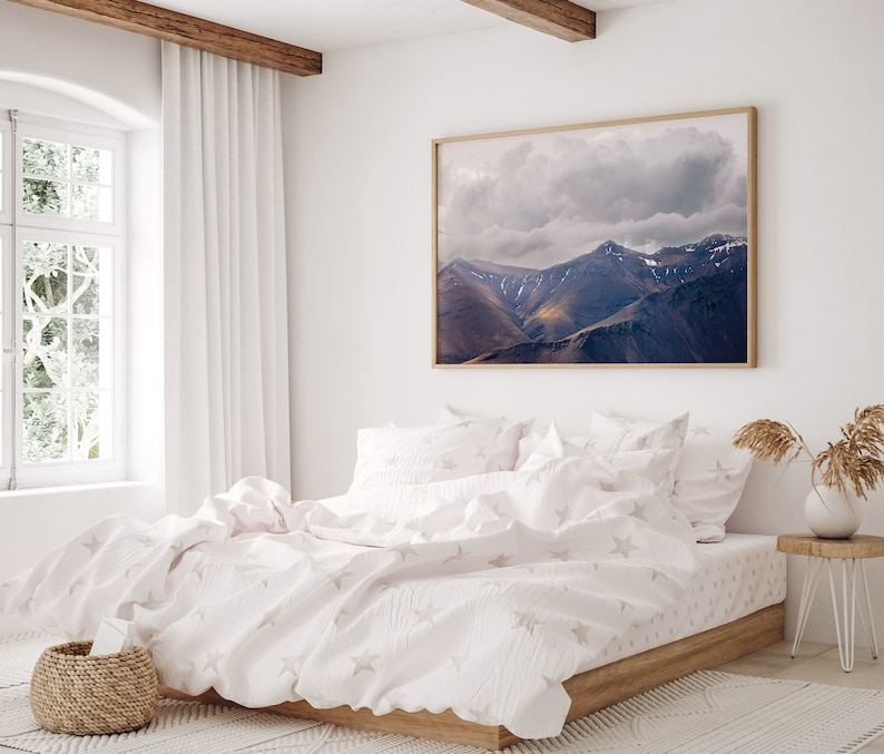 Puede incluir: Una cama blanca con una funda n&oacute;rdica blanca y fundas de almohada blancas. La funda n&oacute;rdica tiene un sutil patr&oacute;n de estrellas. La cama est&aacute; en un dormitorio con una ventana grande y una fotograf&iacute;a enmarcada de una cordillera.
