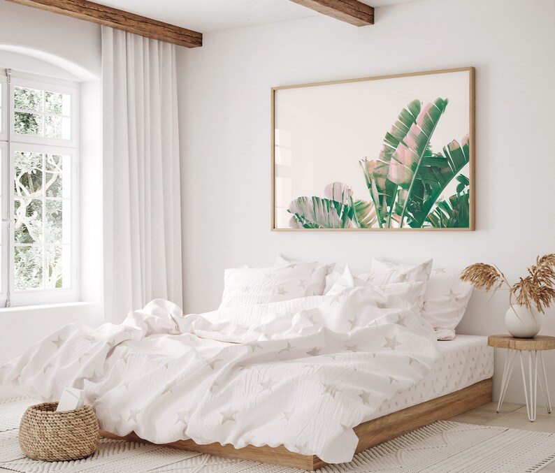 K&ouml;nnte beinhalten: Ein wei&szlig;es Bett mit einem wei&szlig;en Bettbezug und wei&szlig;en Kissenbez&uuml;gen. Der Bettbezug hat ein dezentes Sternenmuster. Das Bett ist mit einer wei&szlig;en Tagesdecke bezogen. An der Wand hinter dem Bett h&auml;ngt ein gerahmtes Bild mit tropischen Bl&auml;ttern.