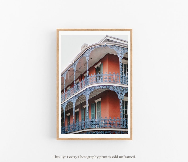 May include: A photograph of a red brick building with blue iron balconies and railings. The building has multiple stories and is decorated with intricate details.