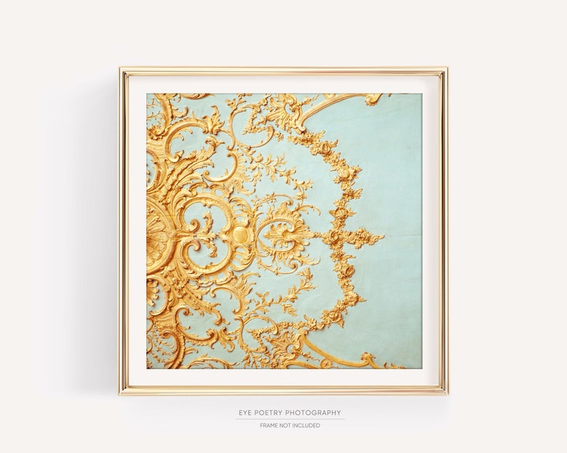 May include: A framed print of a gold and blue ornate design. The design is a repeating pattern of swirls and leaves.