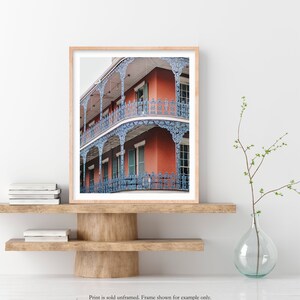 May include: A photograph of a red brick building with blue iron balconies and railings. The building has multiple stories and is decorated with intricate details.