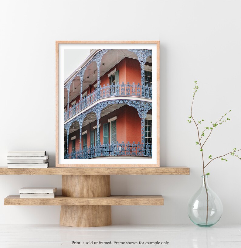 May include: A photograph of a red brick building with blue iron balconies and railings. The building has multiple stories and is decorated with intricate details.