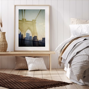 Puede incluir: Una fotograf&iacute;a enmarcada del puente de Brooklyn en la ciudad de Nueva York. La imagen es una fotograf&iacute;a de estilo vintage con un tono sepia descolorido. El puente est&aacute; enfocado, mientras que el horizonte de la ciudad en el fondo est&aacute; desenfocado.