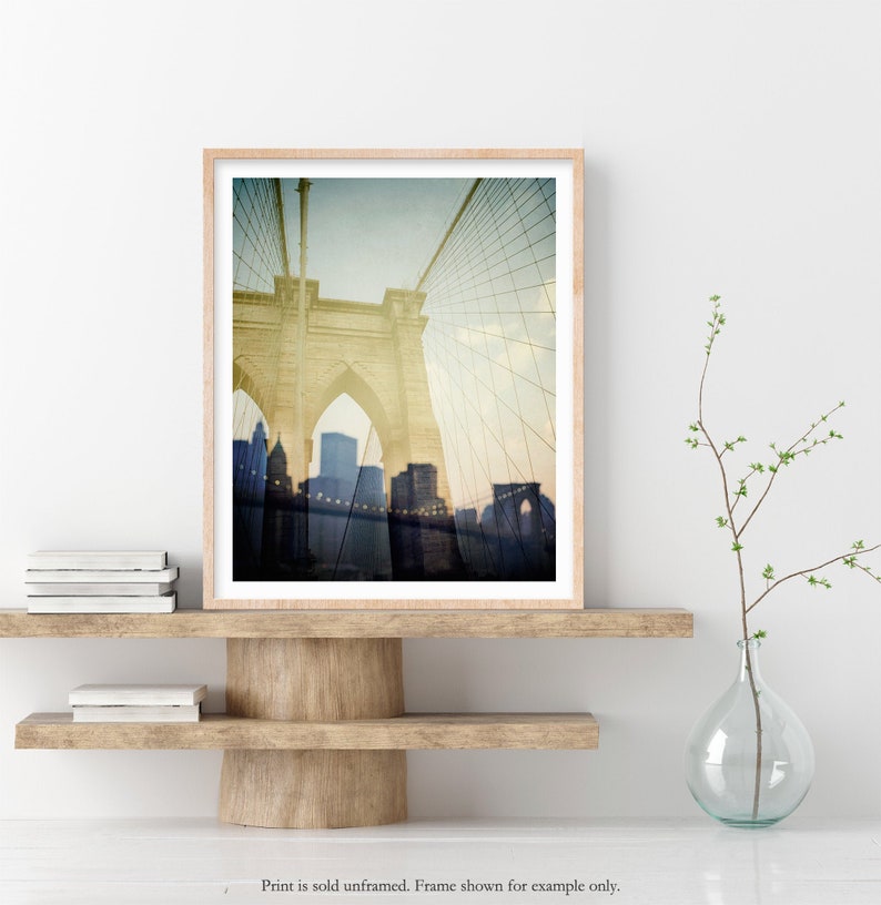 Puede incluir: Una fotograf&iacute;a de estilo vintage del puente de Brooklyn en la ciudad de Nueva York. El puente se muestra en un tono sepia descolorido, con el horizonte de la ciudad visible en el fondo.