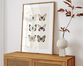 May include: A framed print of six butterflies with white, black, and brown wings arranged in a grid pattern on a beige background.