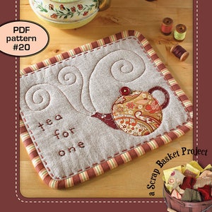 May include: A quilted mug rug with a tea pot design and the text "tea for one". The mug rug is surrounded by a red and white striped border. The image also includes a small wooden basket filled with fabric scraps and the text "a Scrap Basket Project".