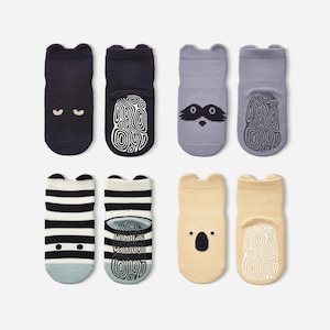 May include: Eight pairs of baby socks in various colors and designs. The socks feature animal faces, stripes, and non-slip grips on the soles. Colors include navy, gray, beige, and black and white stripes. Each sock has a bear-like ear design.