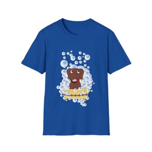 May include: A blue t-shirt with a cartoon illustration of a brown dog in a yellow bathtub surrounded by white bubbles.