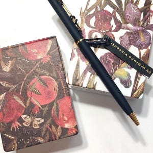 Bloco de notas dourado de Bruno Visconti, íris ou romãs