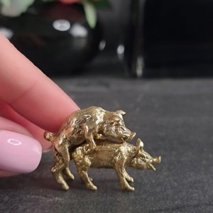 Peut inclure: Une figurine en métal de couleur dorée représentant deux cochons en position d'accouplement.