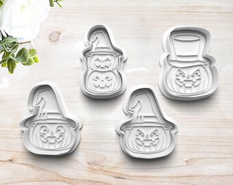 May include: Four white plastic Halloween cookie cutters shaped like pumpkins with different facial expressions. Two of the pumpkins are wearing witch hats and one is wearing a top hat.