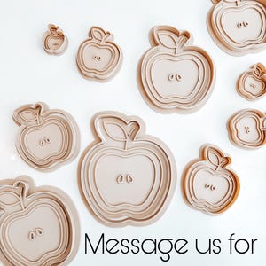 May include: Set of nine beige plastic apple-shaped cookie cutters of various sizes. The largest cutter is about 3 inches in diameter. Message us for custom sizes!