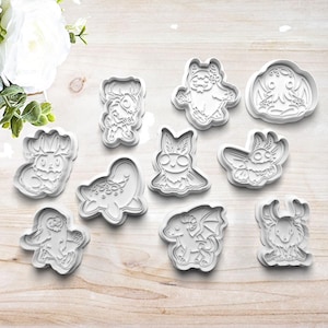May include: Set of ten white plastic cookie cutters shaped like various mythical creatures, including a dragon, a bat, a moth, and a kraken.
