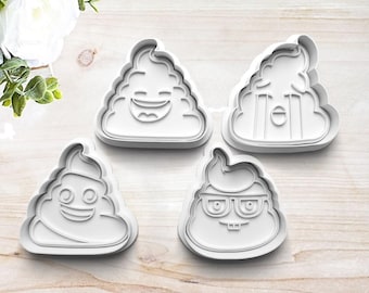May include: Four white plastic cookie cutters shaped like poop with different facial expressions. The cutters are on a light wood surface.