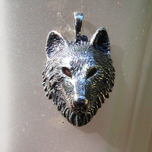 K&ouml;nnte beinhalten: Ein silberner Wolfskopf-Anh&auml;nger mit einem detaillierten Design. Der Anh&auml;nger hat eine strukturierte Oberfl&auml;che und ein realistisches Wolfsgesicht.