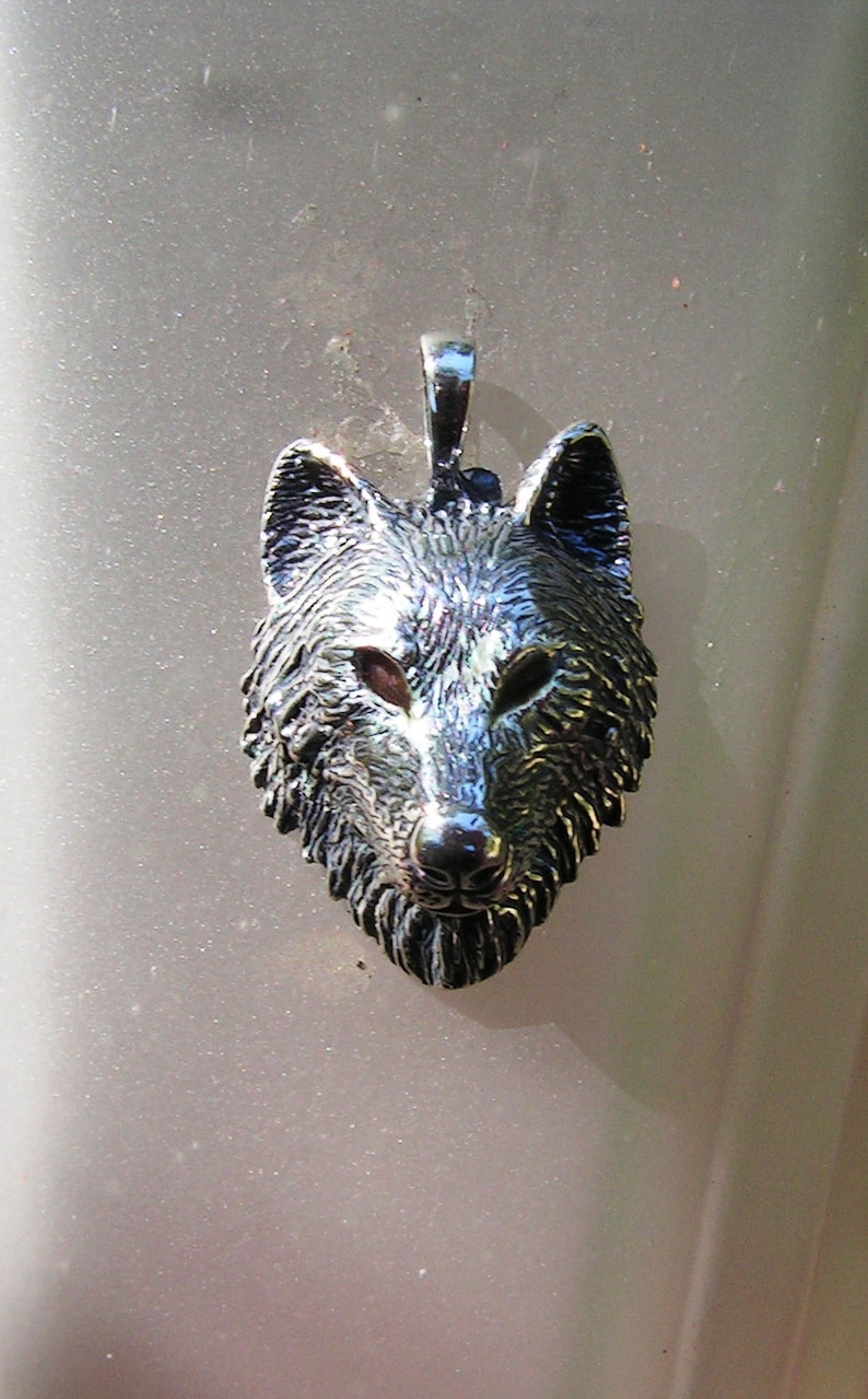 K&ouml;nnte beinhalten: Ein silberner Wolfskopf-Anh&auml;nger mit einem detaillierten Design. Der Anh&auml;nger hat eine strukturierte Oberfl&auml;che und ein realistisches Wolfsgesicht.