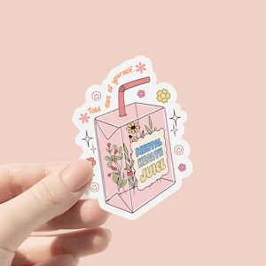 May include: Pink sticker with a cartoon illustration of a juice box with a straw and flowers. The juice box says "Mental Health Juice" and the text above the juice box says "Take care of yourself."