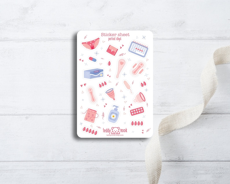 K&ouml;nnte beinhalten: Ein Stickerbogen mit Illustrationen von Menstruationsprodukten, darunter eine Menstruationstasse, Binden, Tampons und ein Kalender. Der Bogen ist wei&szlig; mit rosa und blauen Akzenten und tr&auml;gt die Aufschrift "Sticker sheet period days" und "teddy nook".