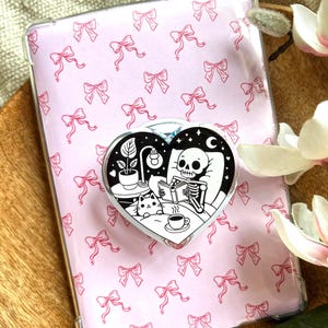 Soporte magnético para Kindle con diseño de esqueleto adorable, estilo otoñal, ideal para amantes de la lectura.