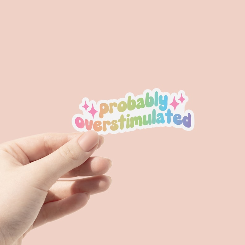 May include: A rainbow-colored sticker with the text "probably overstimulated" and two small stars on either side.
