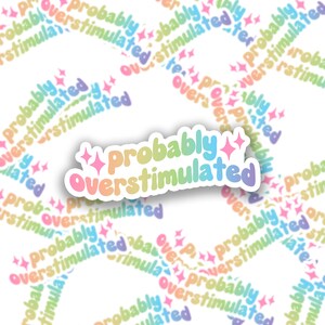May include: A sticker with a rainbow gradient design that says "Probably Overstimulated" with two pink stars on either side.