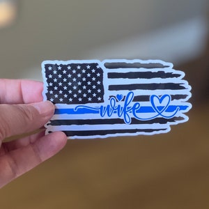 May include: A sticker with a distressed American flag design, a blue line, and the word "wife" with two hearts.