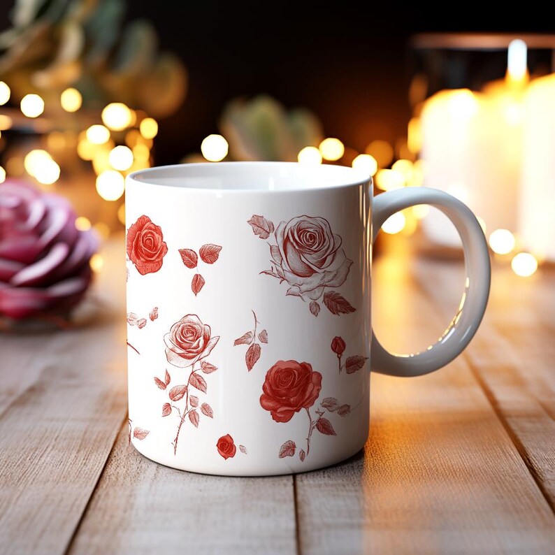 May include: White ceramic mug with a red rose pattern. The mug has a handle and is sitting on a wooden surface.