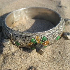 Peut inclure: Une enseigne en bois avec un fond vert et une bordure noire. L'enseigne présente un cheval en bois sculpté en position de dressage, peint dans des tons de brun et de jaune. Le texte "Prancing Pony" est écrit en lettres dorées sur l'enseigne.