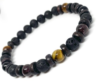 Puede incluir: Un brazalete de cuentas de roca volcánica negra y ojo de tigre con detalles de granate rojo.